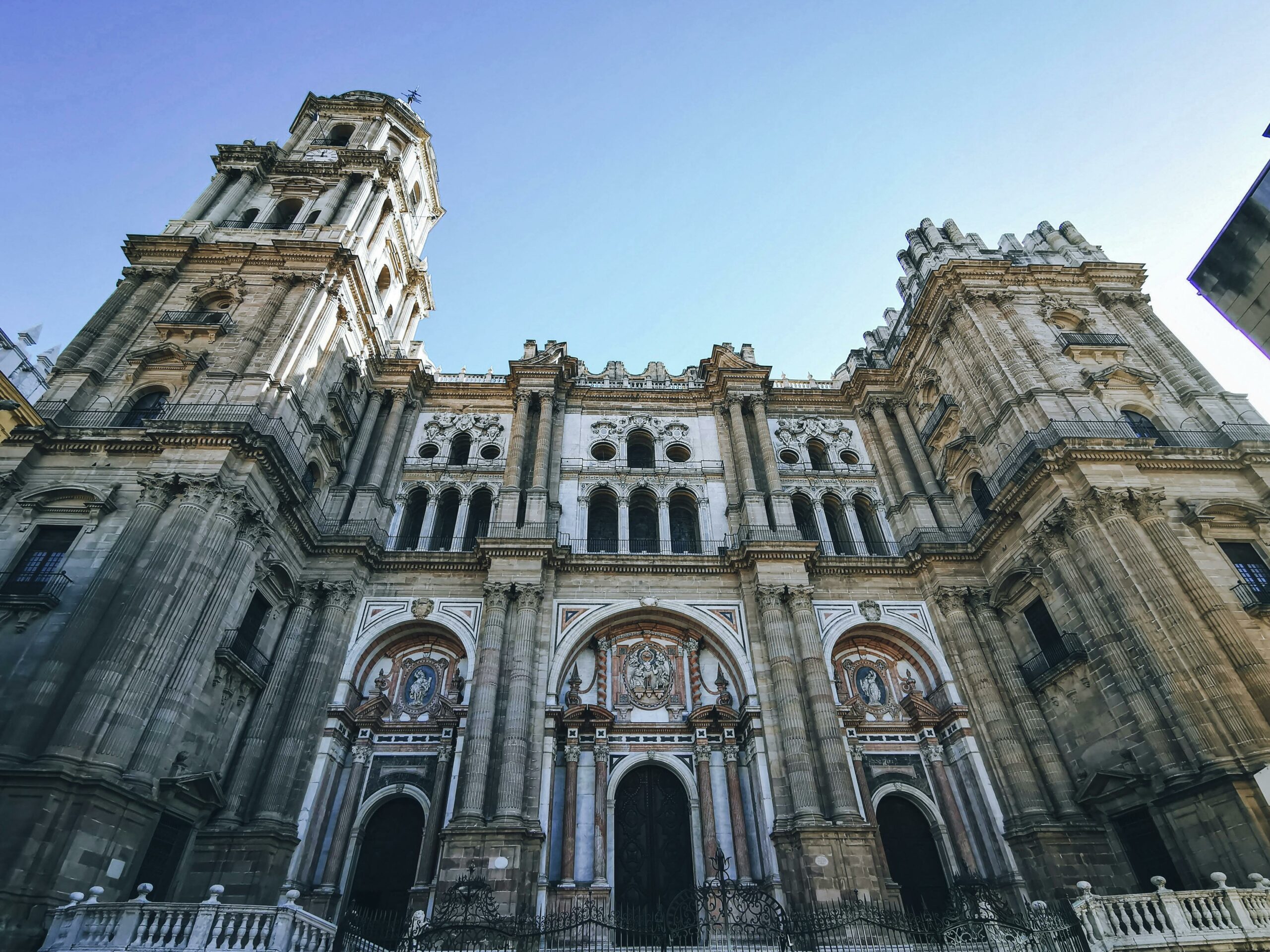 malaga cathedral - La Manquita facade with single tower against blue sky